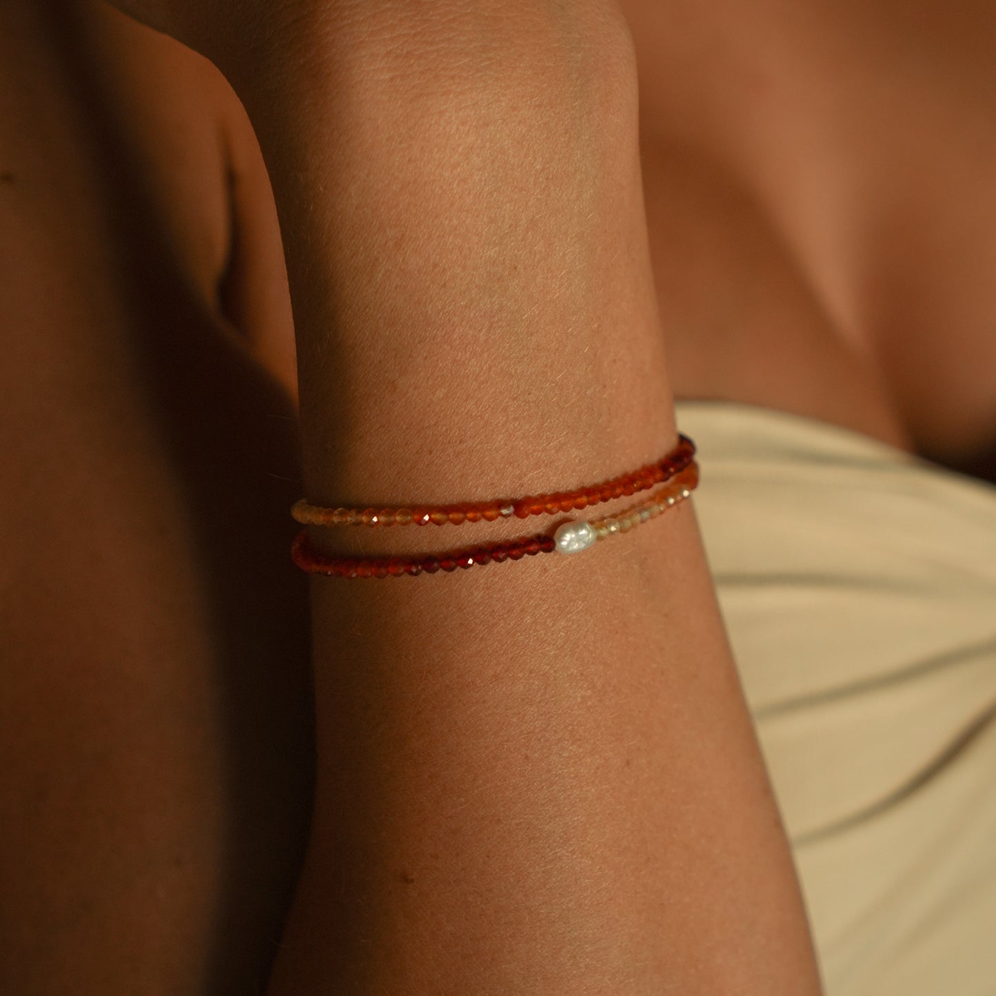 SERRANO bracelet from After-Sun Hours, warm red and orange beads with a single pearl.