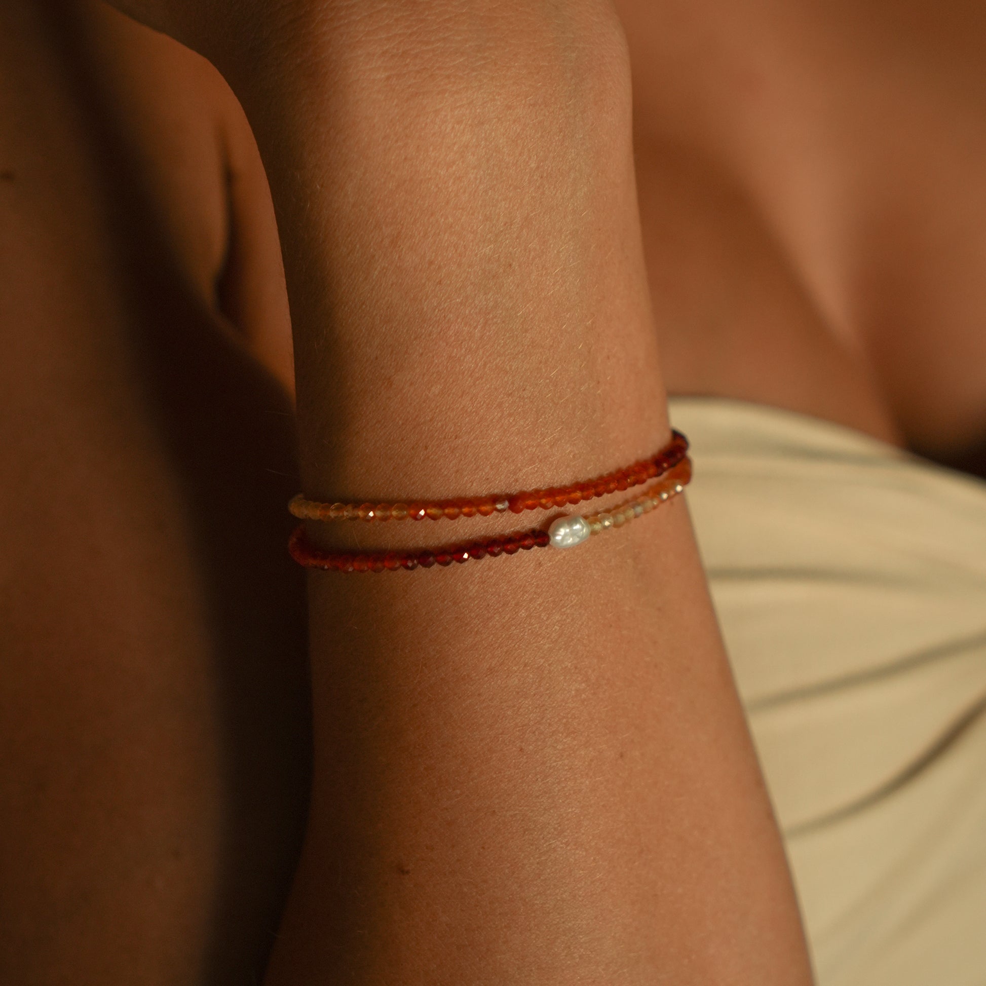SERRANO bracelet from After-Sun Hours, warm red and orange beads with a single pearl.