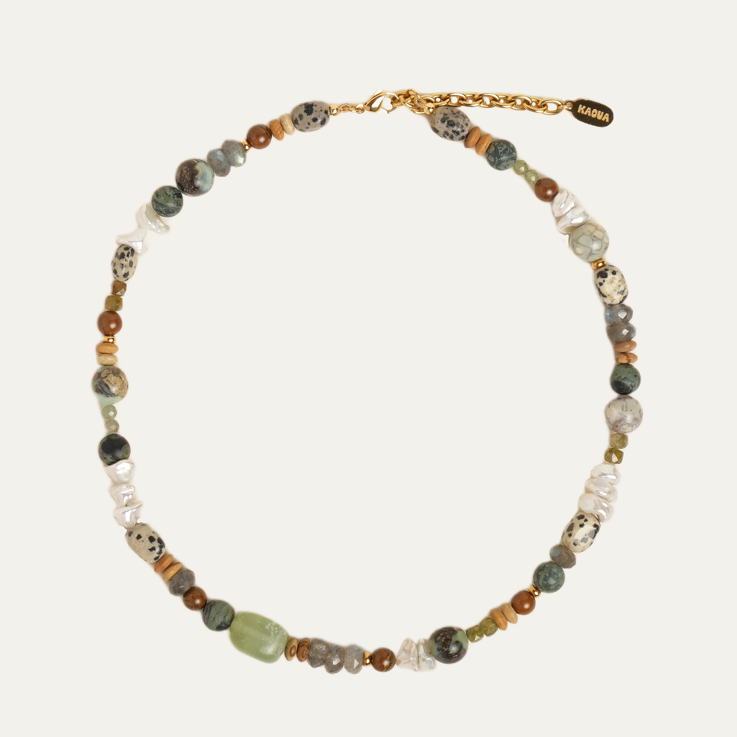 A beaded necklace with a gold chain clasp, featuring a mix of earthy green, brown, white, and black marbled beads, displayed on a light cream background.