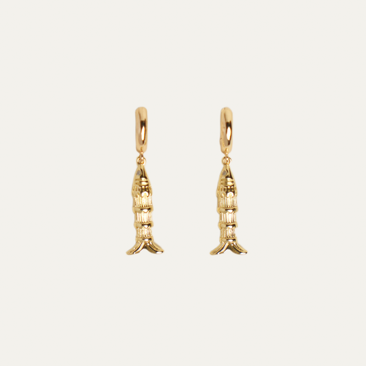 A pair of gold fish dangle earrings, shown against a solid off-white background.